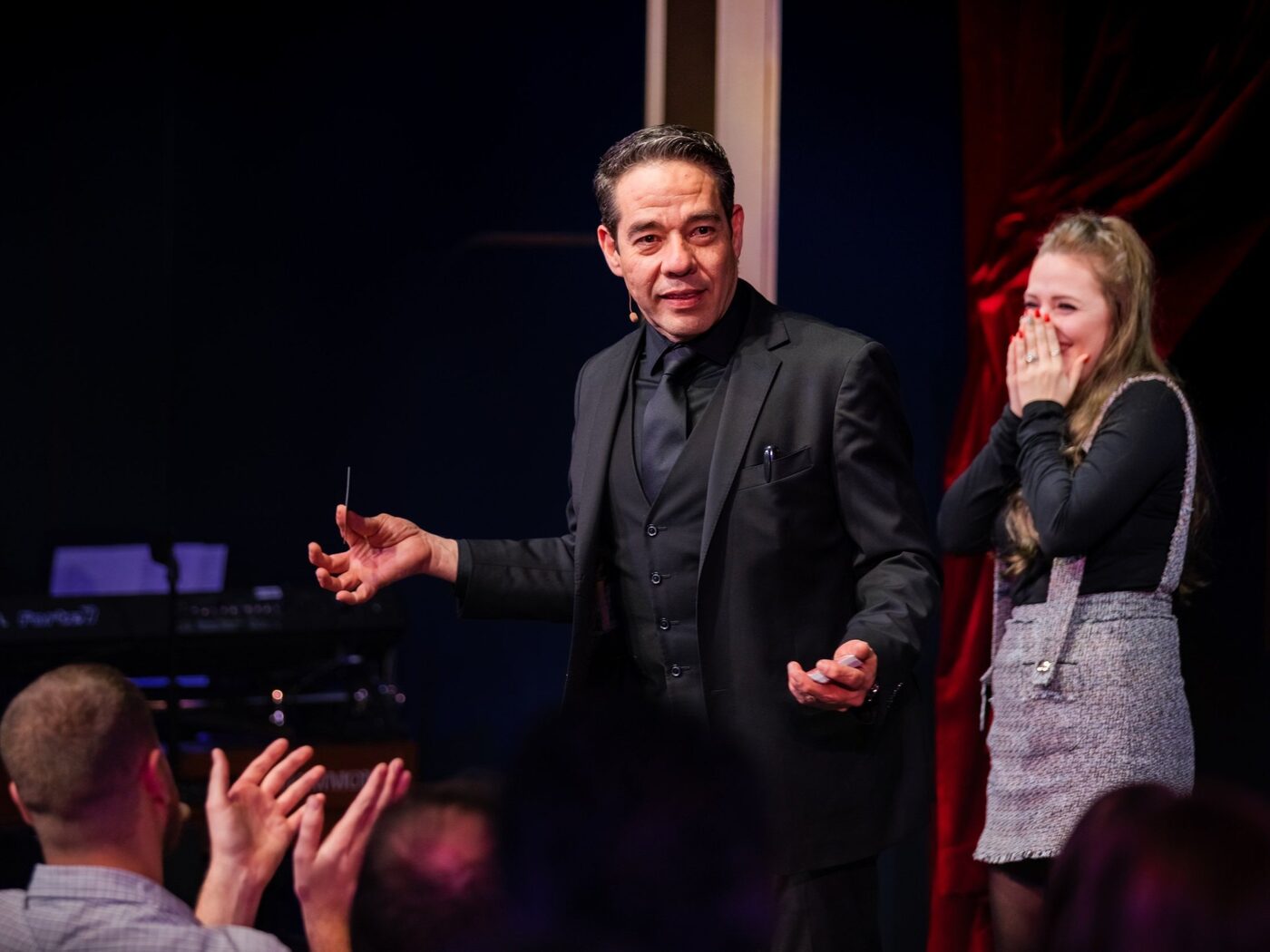 Gozner performing stage magic to a seated audience
